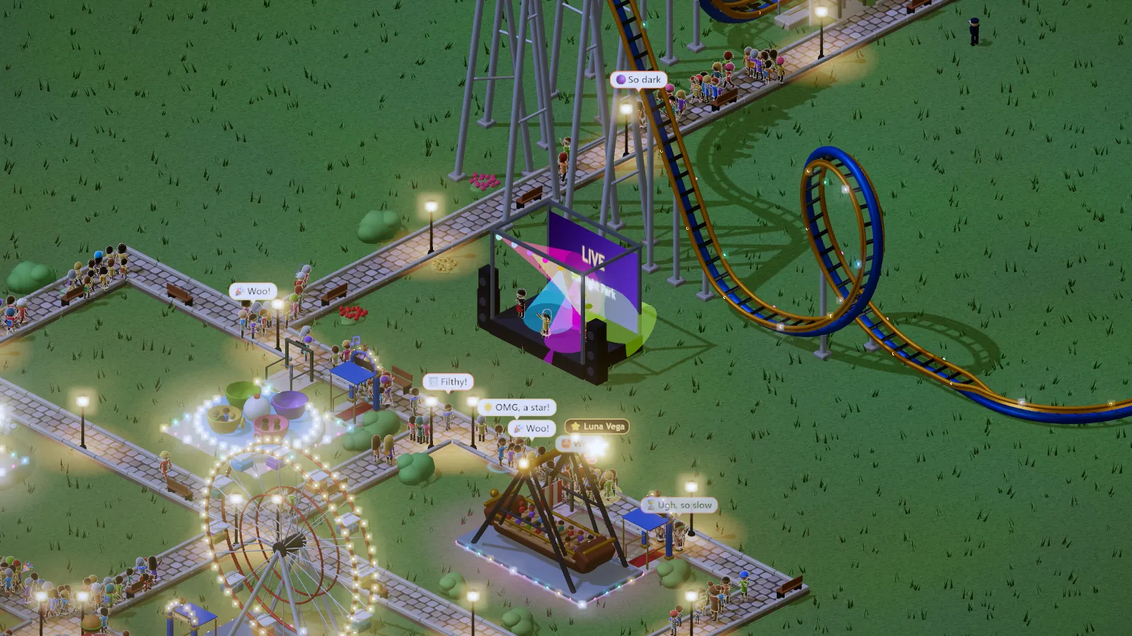 A night concert in the park: a lit stage with a LIVE screen beside a looping coaster, guests all around
